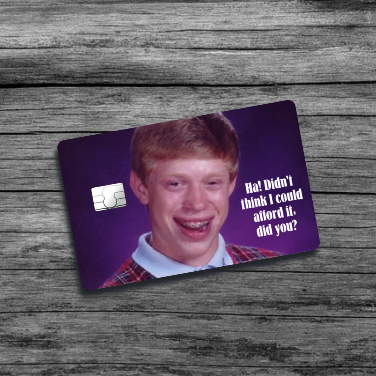 A credit card skin featuring the Bad Luck Brian meme: a school photo of a boy with braces and a plaid vest, smiling awkwardly, symbolizing humorous misfortune.