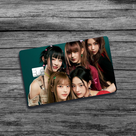 A credit card skin featuring K-Pop group New Jeans, five stylish women with pink berets and clips in their hair, set against a green background.