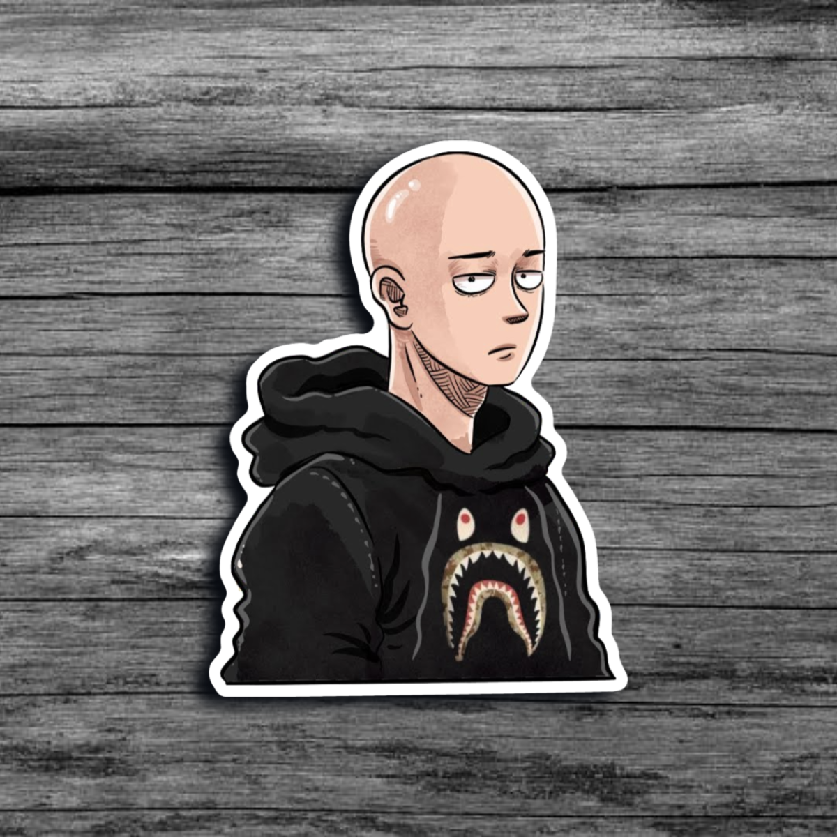 A sticker of Saitama from the anime *One Punch Man*, with a blank expression, wearing a black hoodie with a reptile-like face