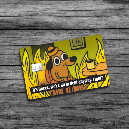 A credit card skin featuring the "This is fine" meme: a dog sitting calmly in a room engulfed in flames, sipping coffee, with a nonchalant expression.